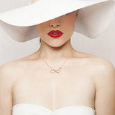 Infinity Necklace 925 Sterling Silver displayed elegantly on a model wearing a sun hat and red lipstick.