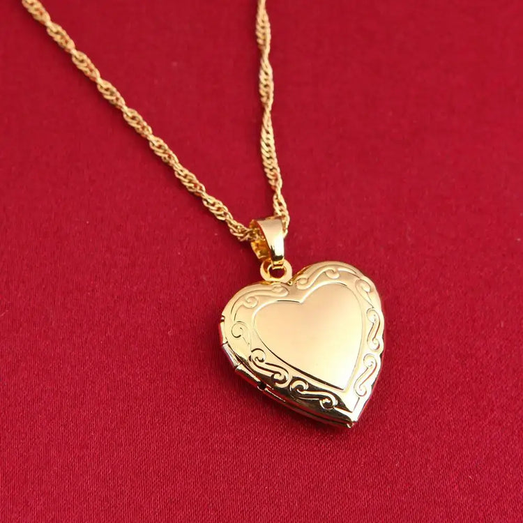 24K Gold Heart Locket Pendant Necklace on a delicate chain against a red background, showcasing its elegant design.